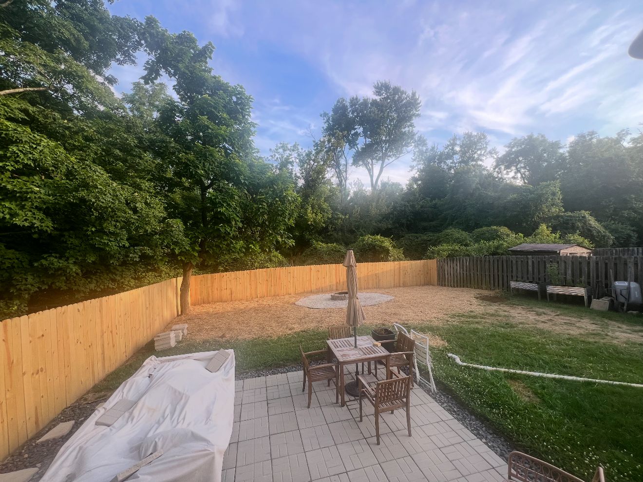 Finished backyard with 150 feet of new wood privacy fence, regraded yard with new grass, and a new fire pit
